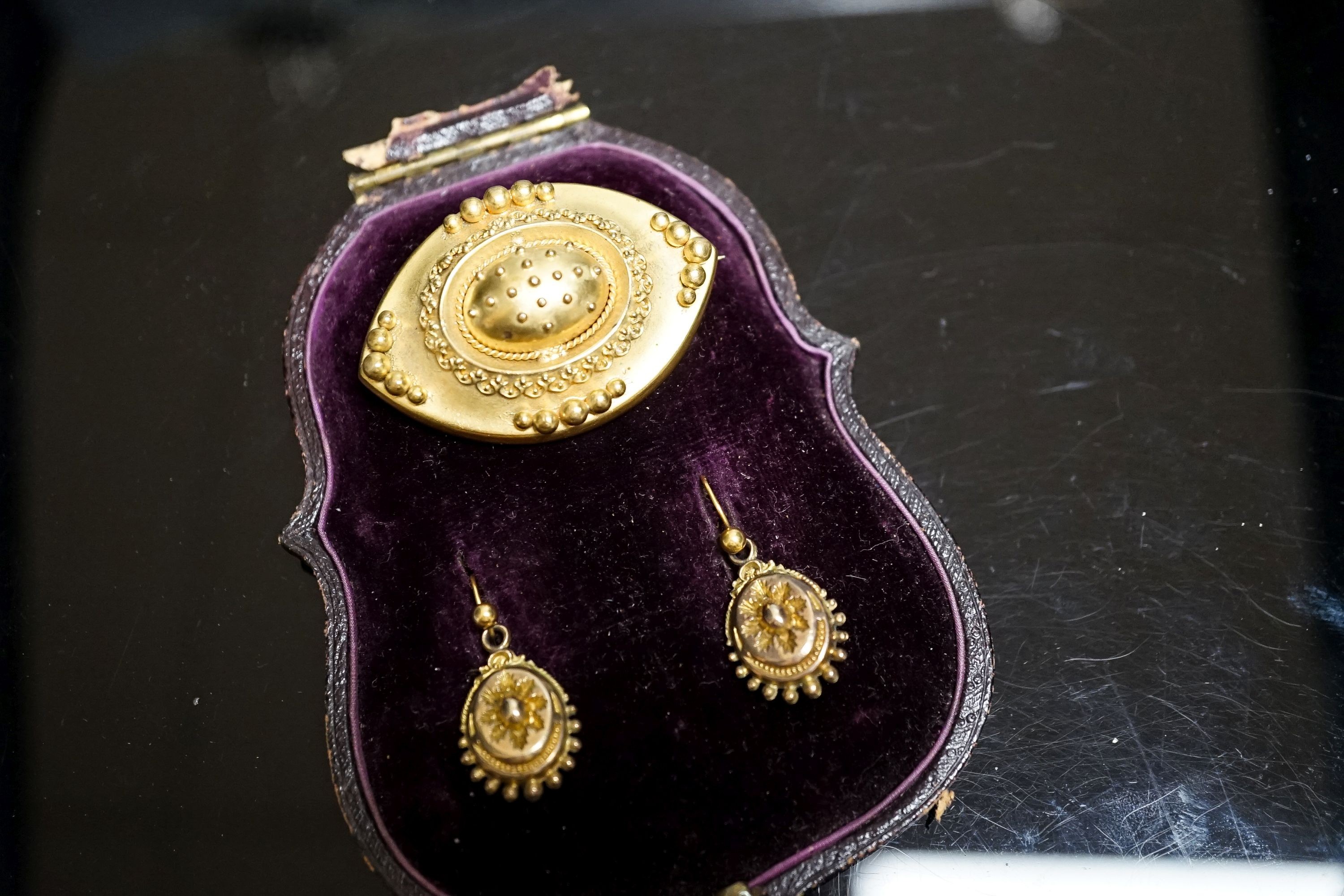 A Victorian yellow metal navette shaped brooch, with bead decoration, 46mm and a pair of similar drop earrings, 22mm, gross weight 17 grams.